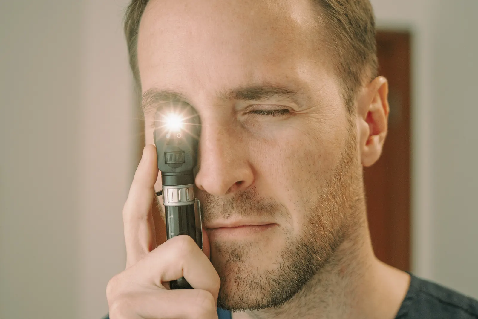 El Dr. Suarez Trujillo realizando un examen ocular con oftalmoscopio